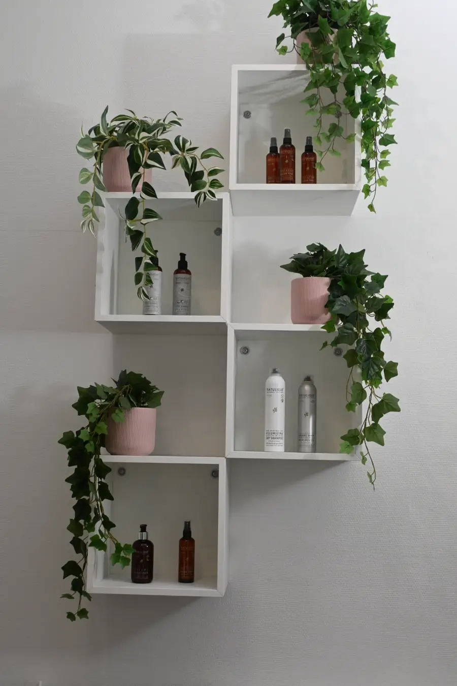 Reolen med NATULIQUE-produkter i Frisør Hyperfokus i Valby